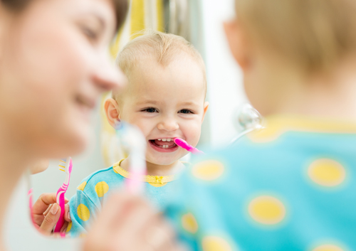 When should my child start using toothpaste and how much should I use?
