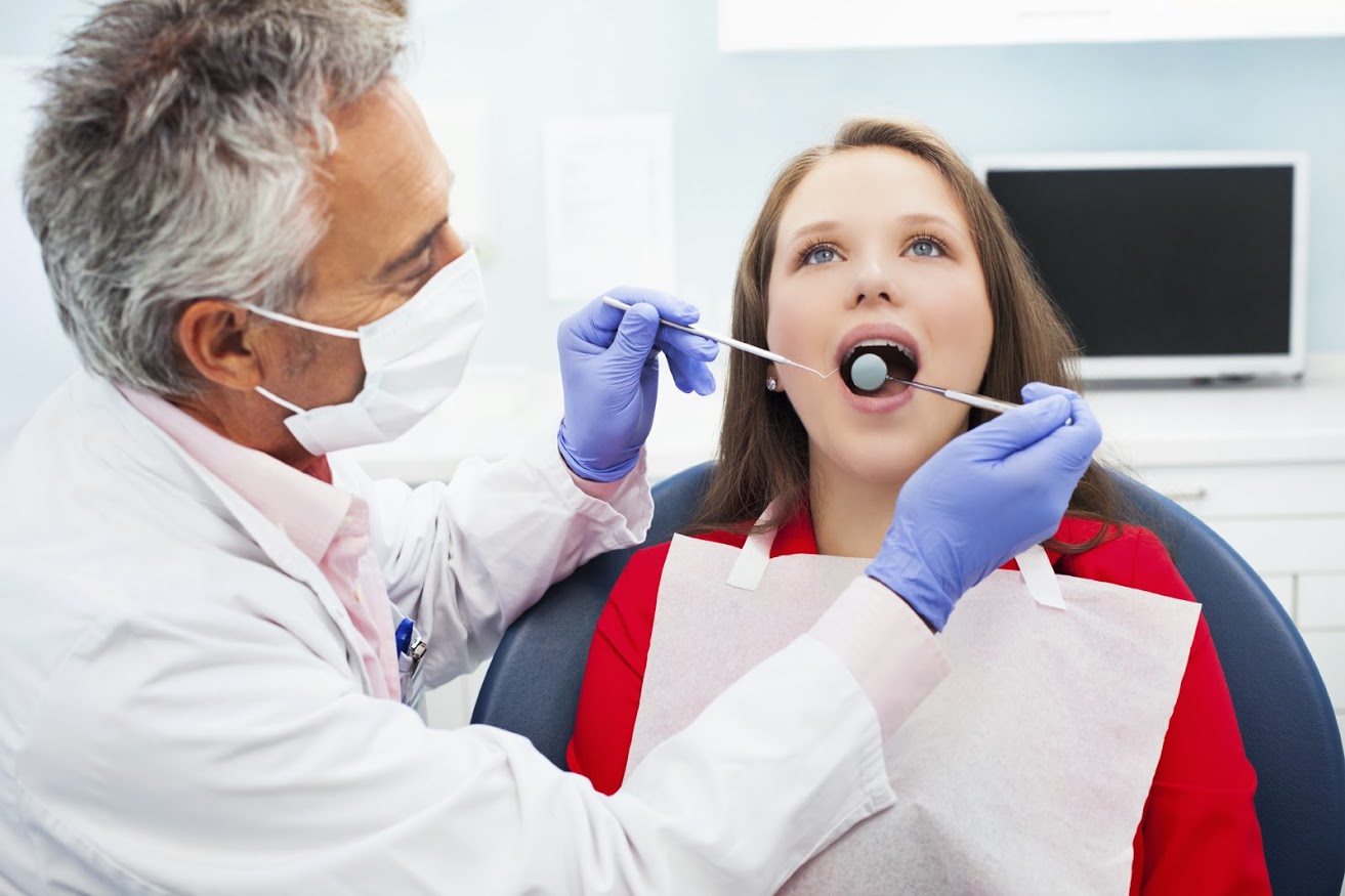A dentist examining a girl's teeth