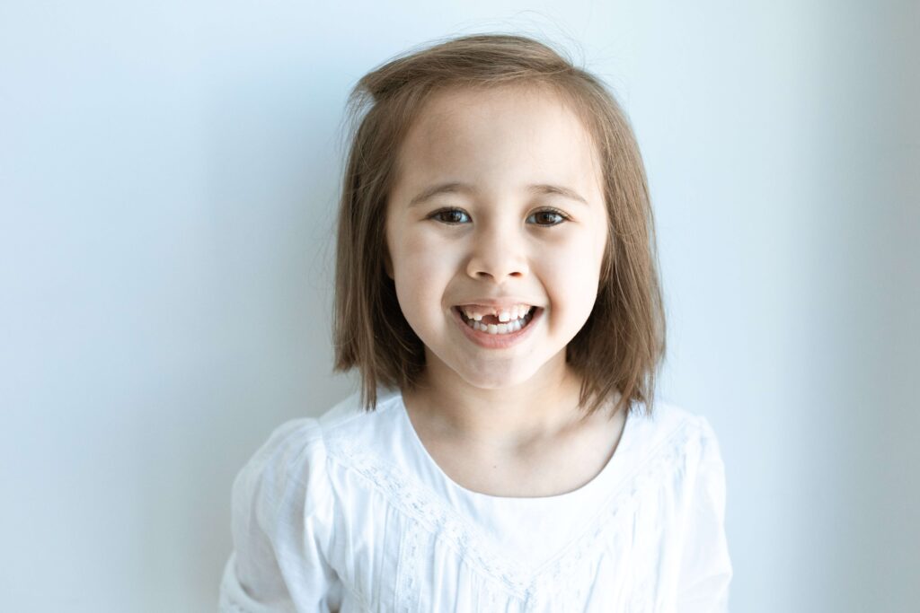 Little girl smiling with a missing front tooth