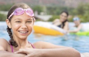 A young girl with braces in a swimming pool.