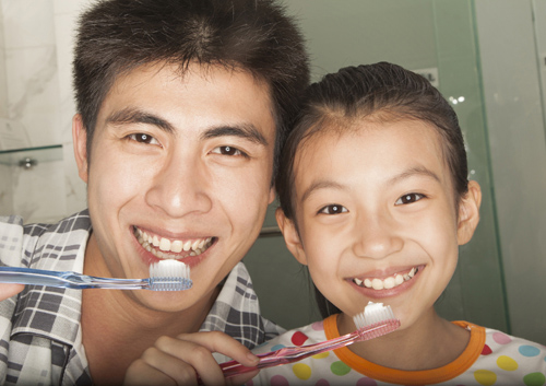 Father & child brushing teeth for the required instructed period in Worcester & Central, MA.