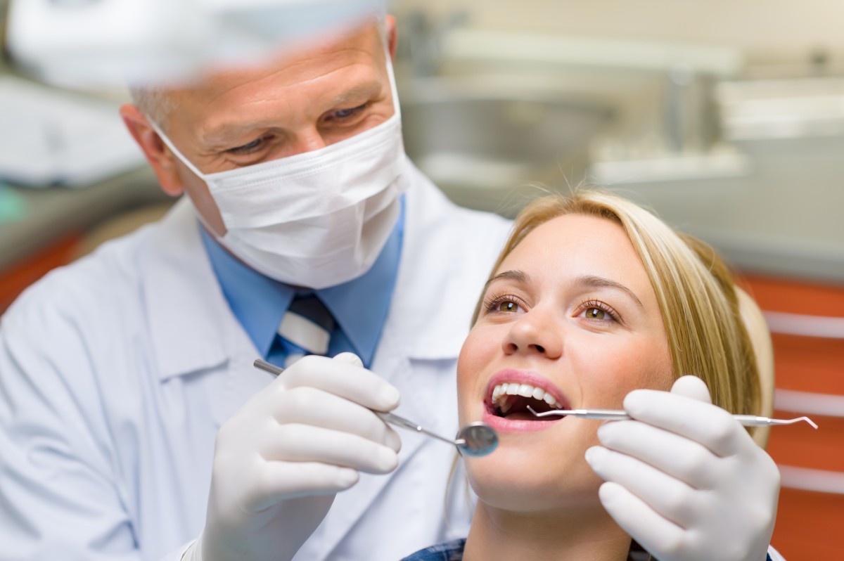 A girl getting her teeth examined at the dentist